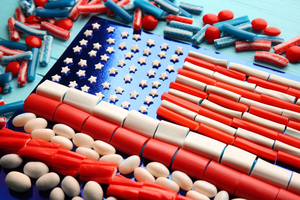 A table topped with candy and an american flag.