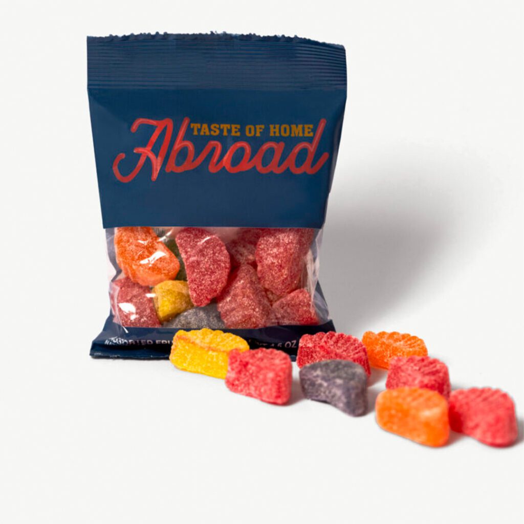 A bag of "abroad" gummy candies with some pieces spilled out onto a white surface.