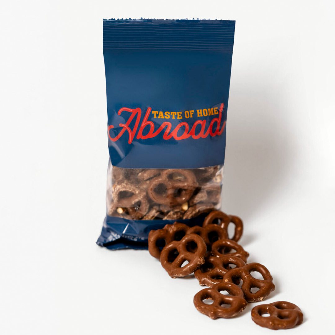 A bag of "taste of home abroad" pretzels with a few pretzels spilled in front.