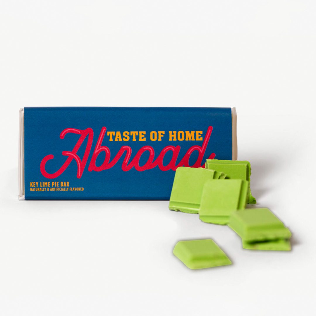 Key lime pie flavored chocolate bar with pieces broken off and arranged in front of the packaging.