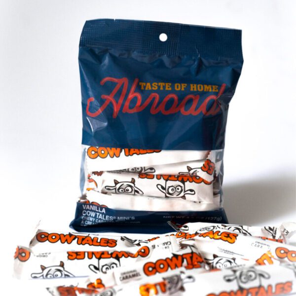 A package and several individual candies labeled "cow tales" with a "taste of home abroad" slogan.
